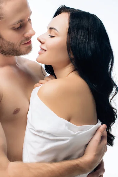 Sexy jeune couple étreignant dans des draps blancs, isolé sur blanc — Photo de stock