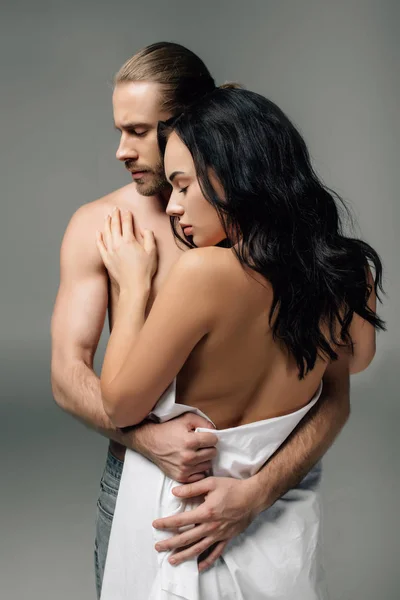 Seducente coppia nuda abbracciata in lenzuola, isolata sul grigio — Foto stock