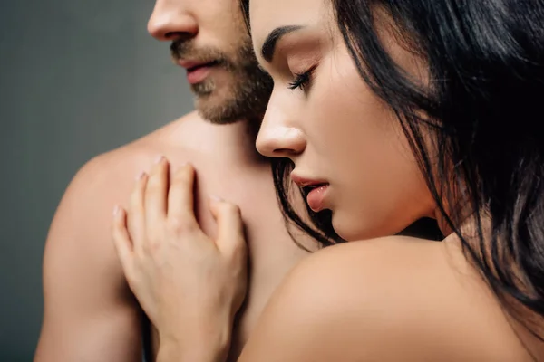 Pareja desnuda abrazándose con los ojos cerrados, aislado en gris - foto de stock