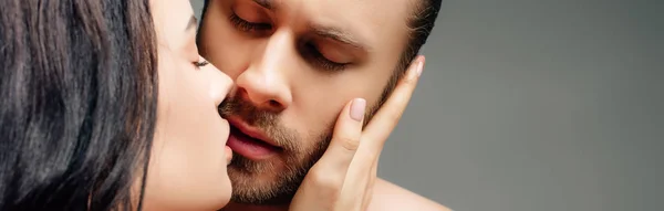 Panoramic shot of seductive naked couple hugging and going to kiss, isolated on grey — Stock Photo