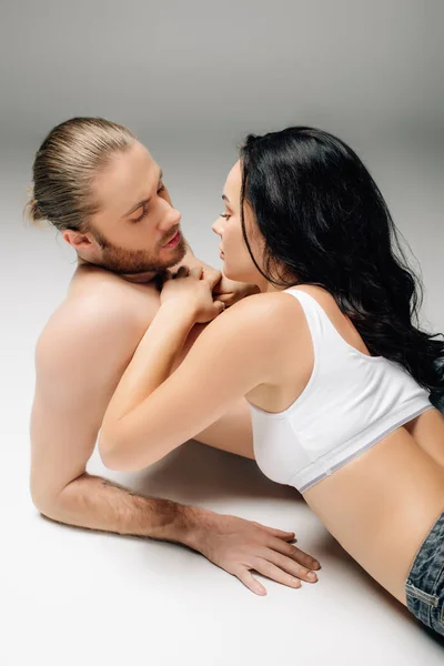 Sensual jovem casal em roupa interior deitado no branco — Fotografia de Stock