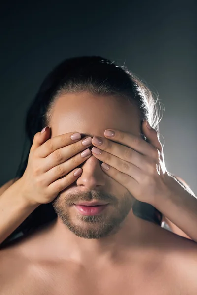 Petite amie fermer les yeux de l'homme sur gris avec contre-jour — Photo de stock