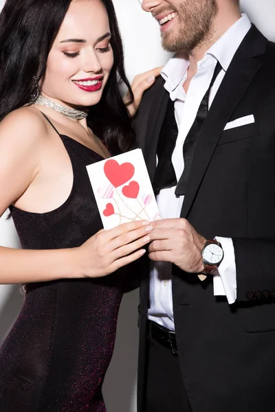 Beautiful young happy couple holding valentines day card on white — Stock Photo
