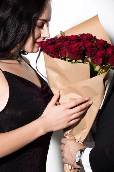 Schöne junge Frau mit einem Strauß roter Rosen am Valentinstag auf weiß — Stockfoto