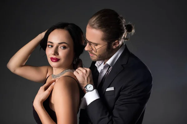 Young man wearing necklace on his girlfriend on valentines day, isolated on grey — Stock Photo