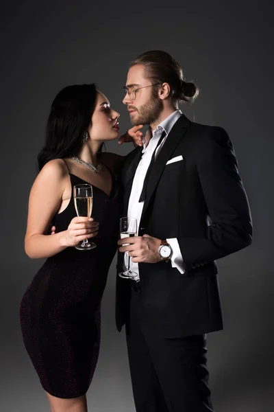 Beautiful couple with champagne glasses for valentines day on grey — Stock Photo
