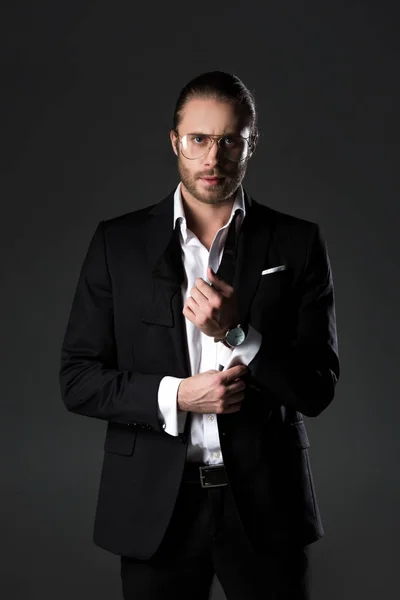 Елегантний красивий чоловік в чорному костюмі ізольований на сірому — стокове фото