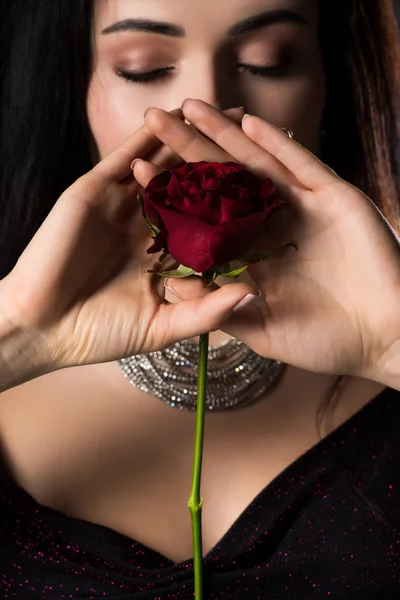 Attraente giovane donna in possesso di fiore di rosa, isolato su grigio — Foto stock