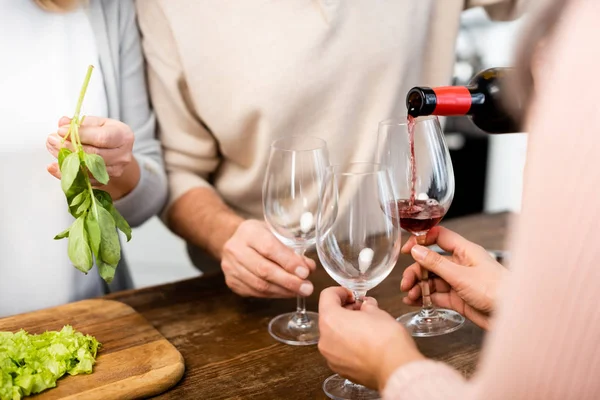 Vista cortada do homem derramando vinho para copos para amigos — Fotografia de Stock