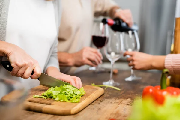 Abgeschnittene Ansicht einer Frau, die grünen Salat auf Schneidebrett schneidet — Stockfoto