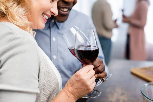 Vista ritagliata di afro americano uomo clinking con amico sorridente in cucina — Foto stock