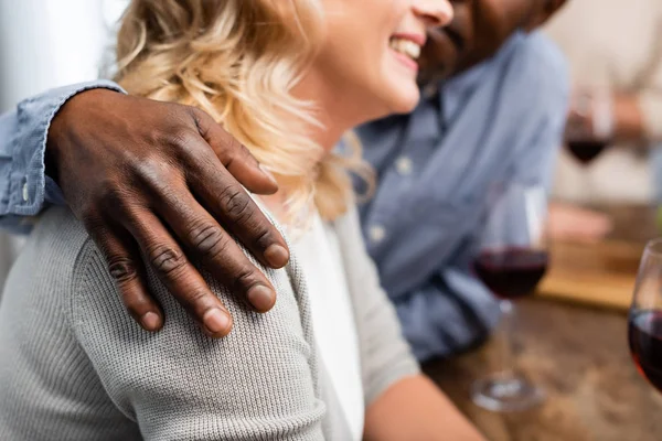 Vista recortada del hombre afroamericano abrazando a su amigo sonriente - foto de stock