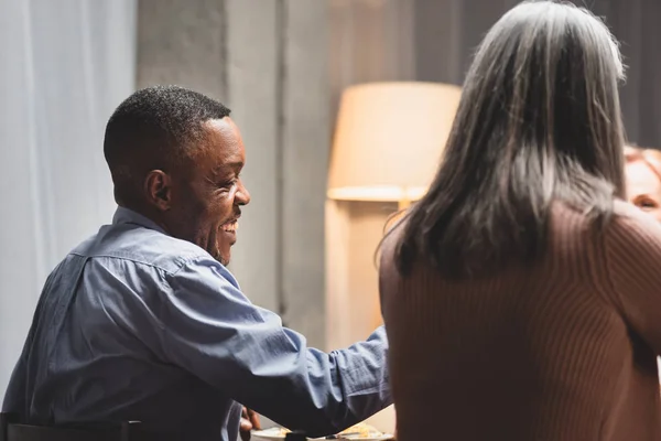 Visão traseira do homem e da mulher americanos africanos que sorri durante o jantar — Fotografia de Stock