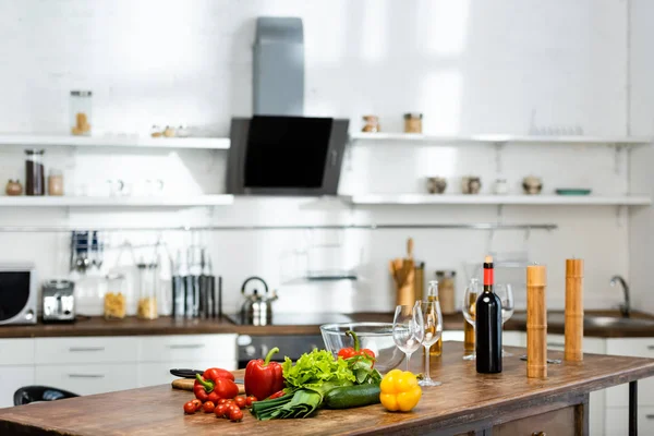 Legumes. garrafas com vinho e cerveja, copos de vinho, tigela, Moinho de Pimenta, moinho de sal em mesa de madeira na cozinha — Fotografia de Stock