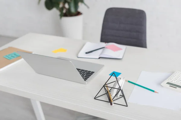 Foco selectivo de la computadora portátil cerca del portátil en la mesa - foto de stock