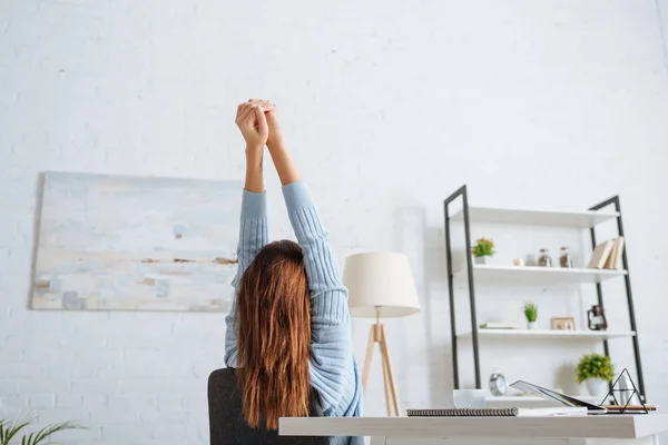 Back view of girl chilling and stretching near table at home — Stock Photo