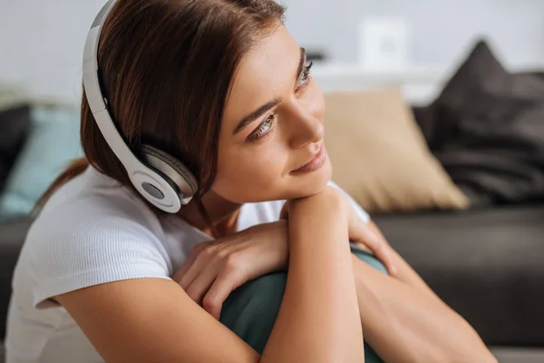 Chica de ensueño escuchando música en los auriculares en casa - foto de stock