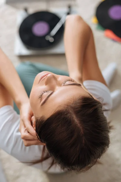 Vista dall'alto di sognante giovane donna vicino dischi in vinile — Foto stock