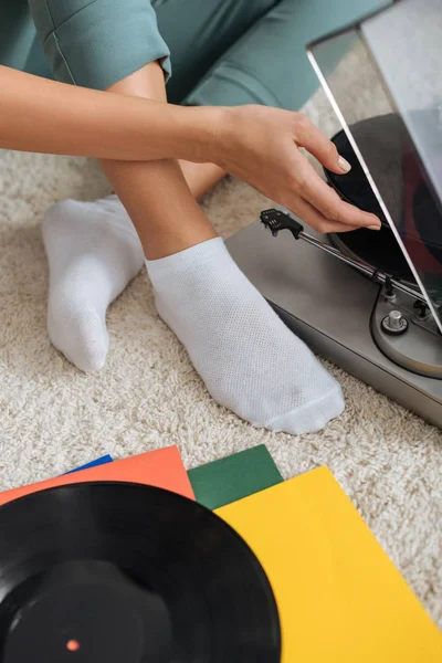 Cropped view of girl in white socks touching vinyl record near retro record player — Stock Photo