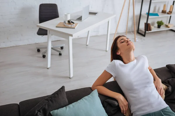 Schöne junge Frau entspannt sich zu Hause auf dem Sofa — Stockfoto