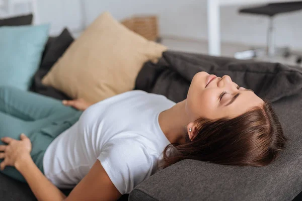 Foyer sélectif de la fille reposant sur le canapé dans le salon — Photo de stock