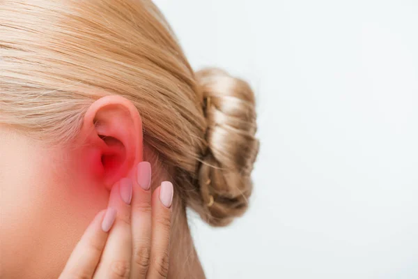 Vista recortada de mujer rubia tocando oído inflamado aislado en blanco - foto de stock