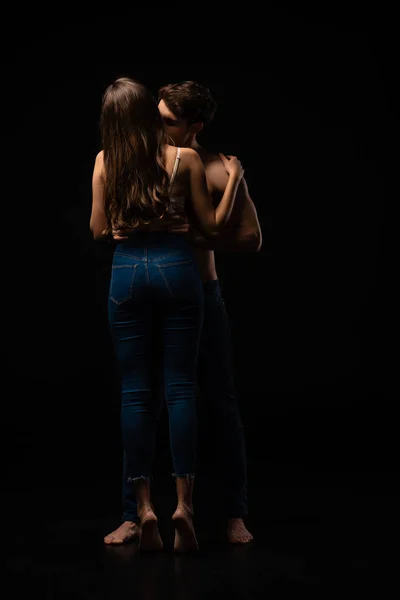 Вид сзади на сексуальную молодую пару, целующуюся на черном — стоковое фото