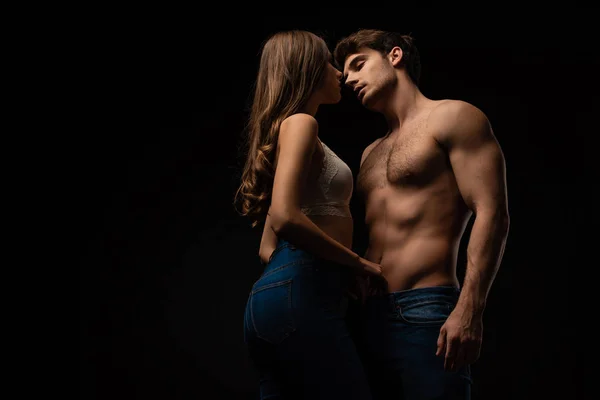 Sexy young couple kissing isolated on black — Stock Photo