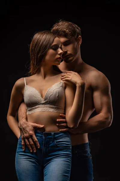 Sexy jovem casal abraço isolado no preto — Fotografia de Stock