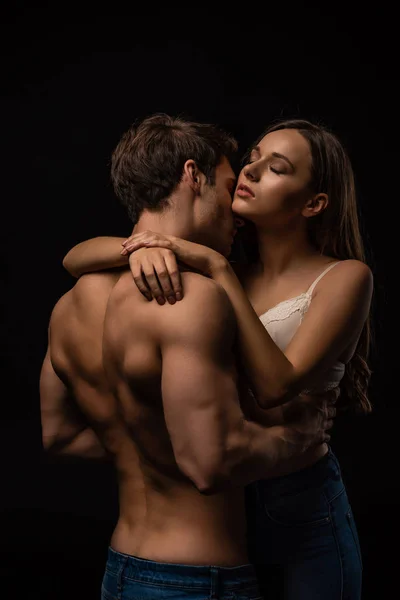 Sexy jeune couple passionnément câlin avec les yeux fermés isolé sur noir — Photo de stock