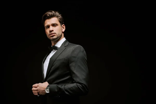 Eleganter Mann im Anzug blickt isoliert auf schwarze Kamera — Stockfoto