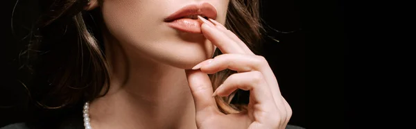 Panoramic shot of woman touching lips isolated on black — Stock Photo