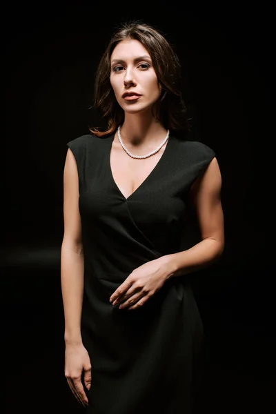 Elegante Frau im Kleid blickt vereinzelt in die Kamera auf schwarz — Stockfoto