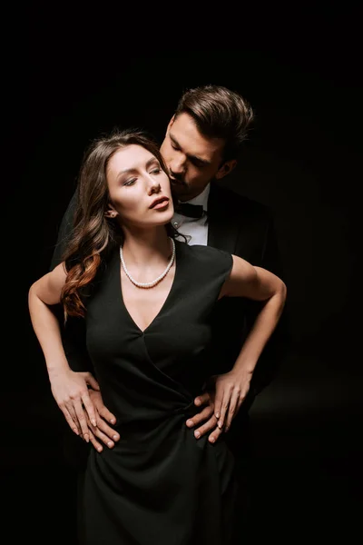 Mann umarmt attraktive Frau im schwarzen Kleid — Stockfoto
