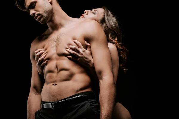 Passionné jeune femme grattant sexy homme isolé sur noir — Photo de stock
