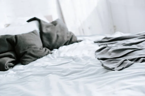 Selective focus of blanket on bed with grey pillows — Stock Photo