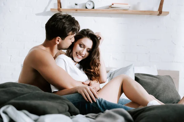 Selective focus of man kissing happy girlfriend at home — Stock Photo