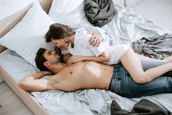 Vue supérieure de fille heureuse couché avec bel homme sur le lit — Photo de stock