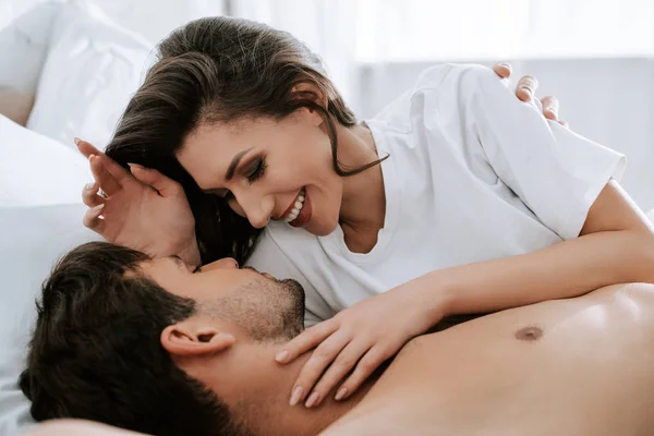 Вибірковий фокус щасливої дівчини, що лежить з красивим чоловіком на ліжку — стокове фото