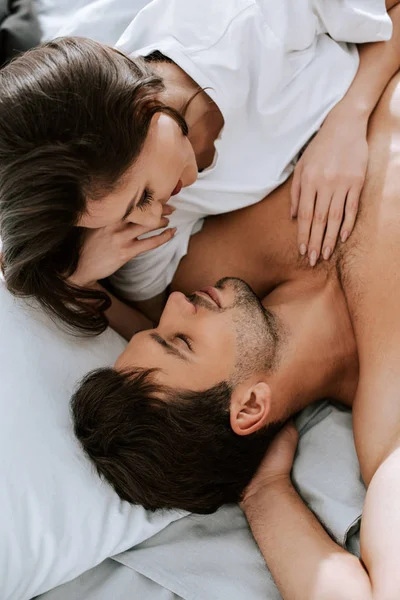 Vista superior de la mujer feliz acostado con un hombre guapo en la cama — Stock Photo