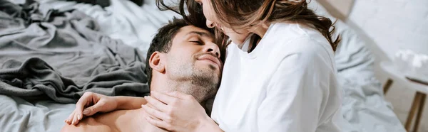 Panoramic shot of girl looking at handsome muscular boyfriend in bedroom — Stock Photo