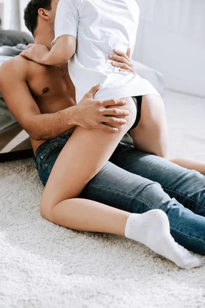 Обрезанный вид сексуальной женщины, обнимающей мужчину без рубашки в спальне — стоковое фото