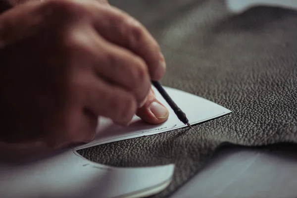 Ausgeschnittene Ansicht des Schusters, der Leder mit speziellem Stift in der Nähe der Schablone markiert — Stockfoto