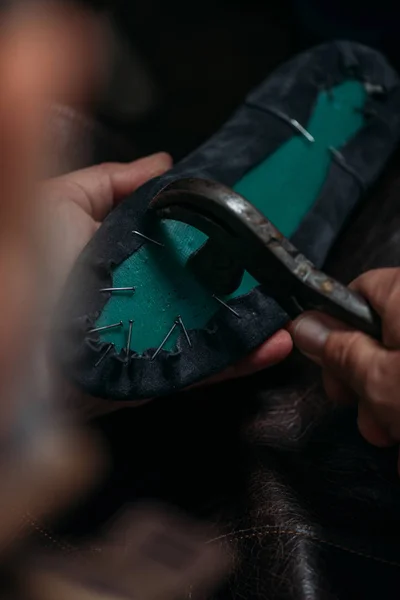 Обрезанный вид сапожника удаление ногтей из ботинка с помощью выдергивателя ногтей — стоковое фото