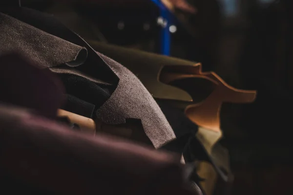 Selective focus of cut pieces of genuine leather in workshop — Stock Photo