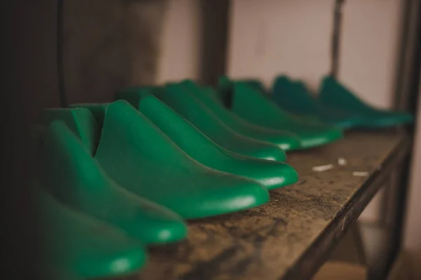 Selective focus of different shoe lasts on rack in workshop — Stock Photo