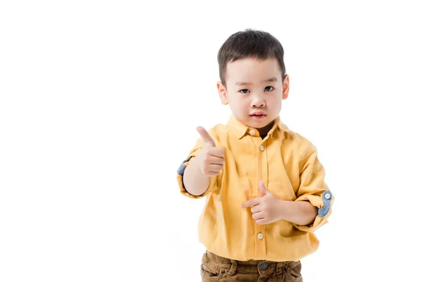 Серйозний азіатський хлопчик показує великий палець вгору ізольовано на білому — стокове фото