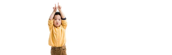 Панорамний знімок здивованого азіатського хлопчика, який вказує вгору ізольовано на білому — стокове фото