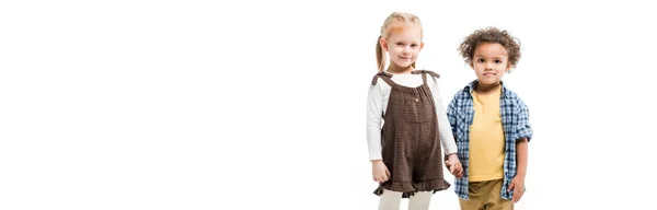 Plano panorámico de un par de niños felices multiculturales tomados de la mano, aislados en blanco - foto de stock