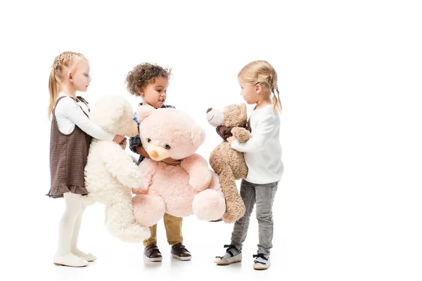 Чарівні мультикультурні діти тримають плюшевих ведмедів, ізольовані на білому — стокове фото